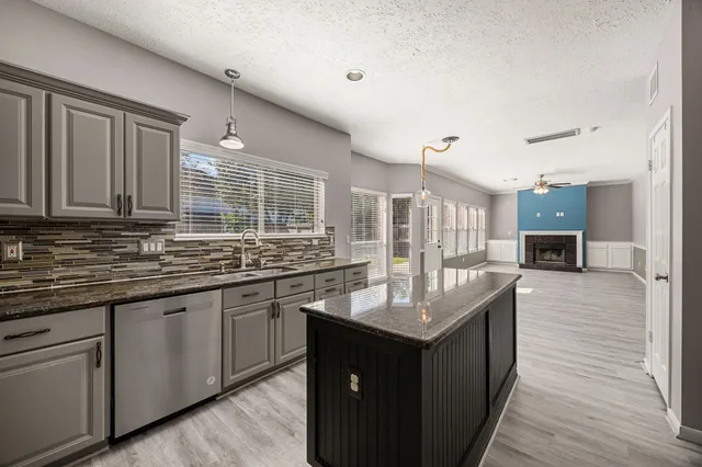 a kitchen with granite countertop a sink and cabinets