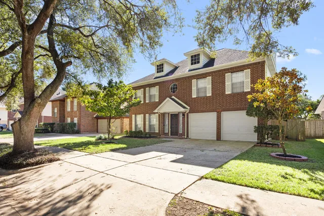 a front view of a house with a yard and trees