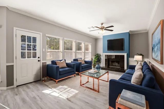 a living room with furniture a flat screen tv and a fireplace