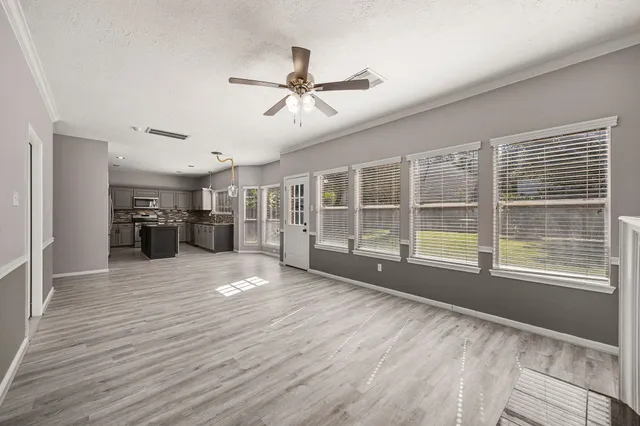 a view of empty room with wooden floor and windows