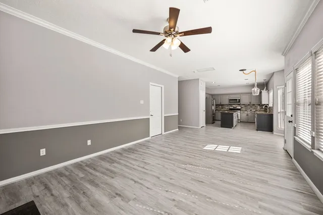 a view of a livingroom with a ceiling fan and wooden floor