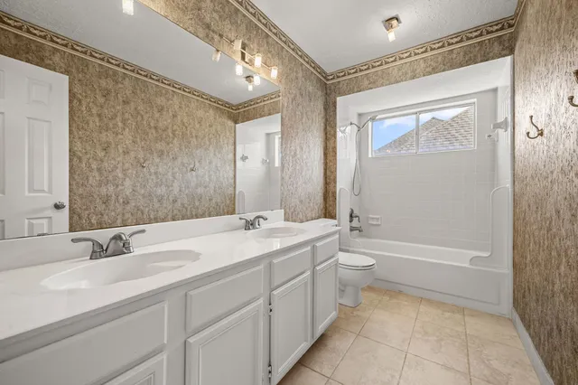 a bathroom with a double vanity sink toilet mirror and bathtub