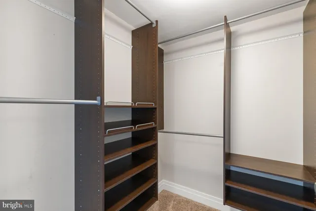 a view of walk in closet with empty racks