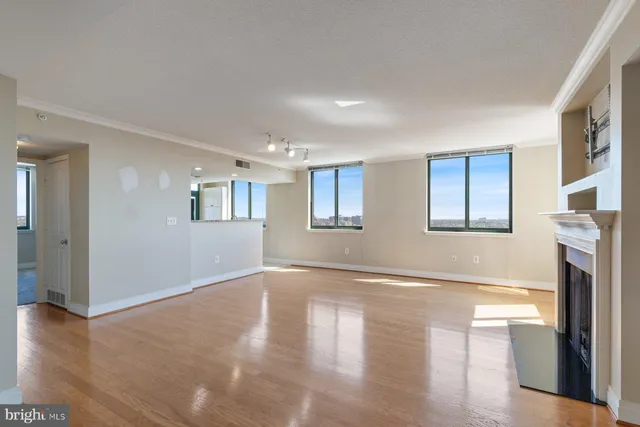 a view of empty room with wooden floor and fireplace