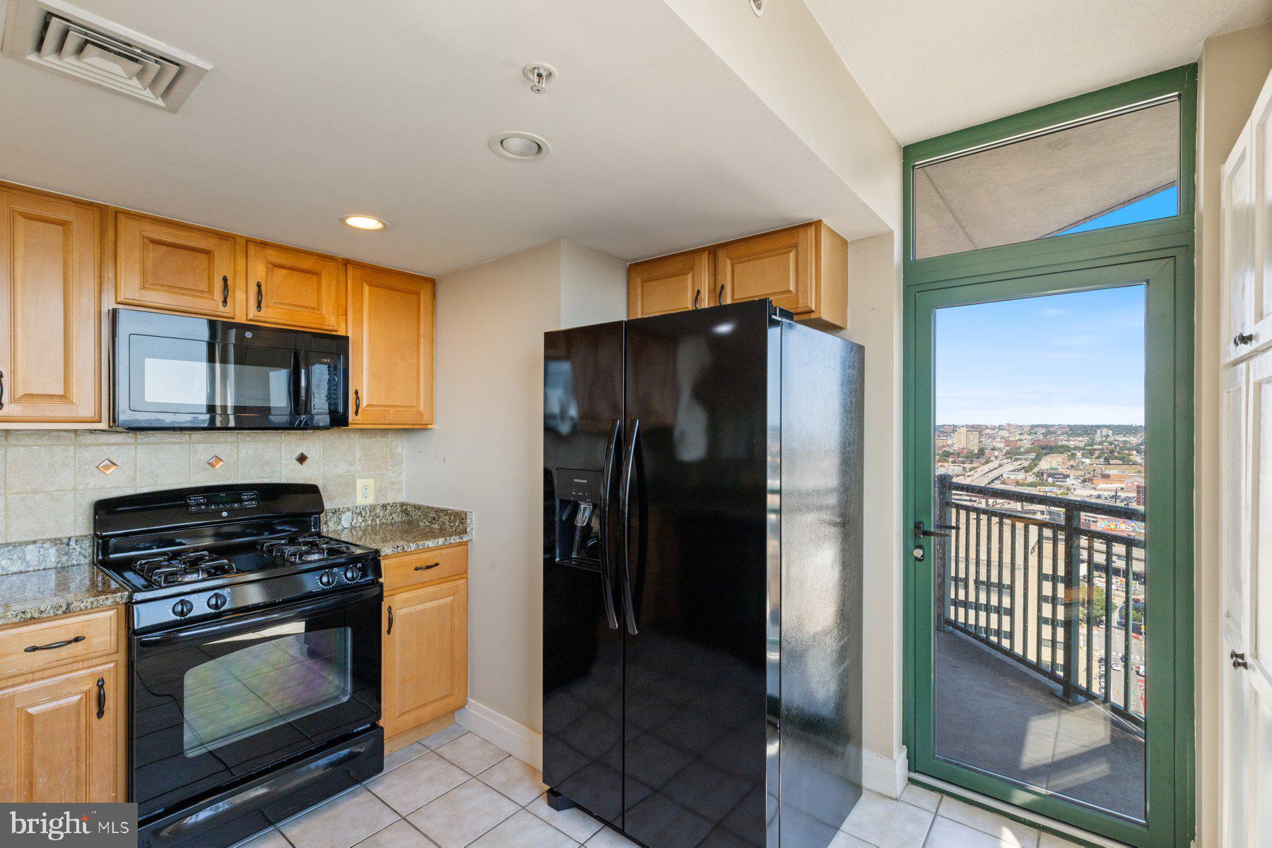 414 Water Street, Unit 2512 Baltimore, MD 21202 - Photo 8 of 40 a kitchen with stainless steel appliances granite countertop a refrigerator and a stove top oven