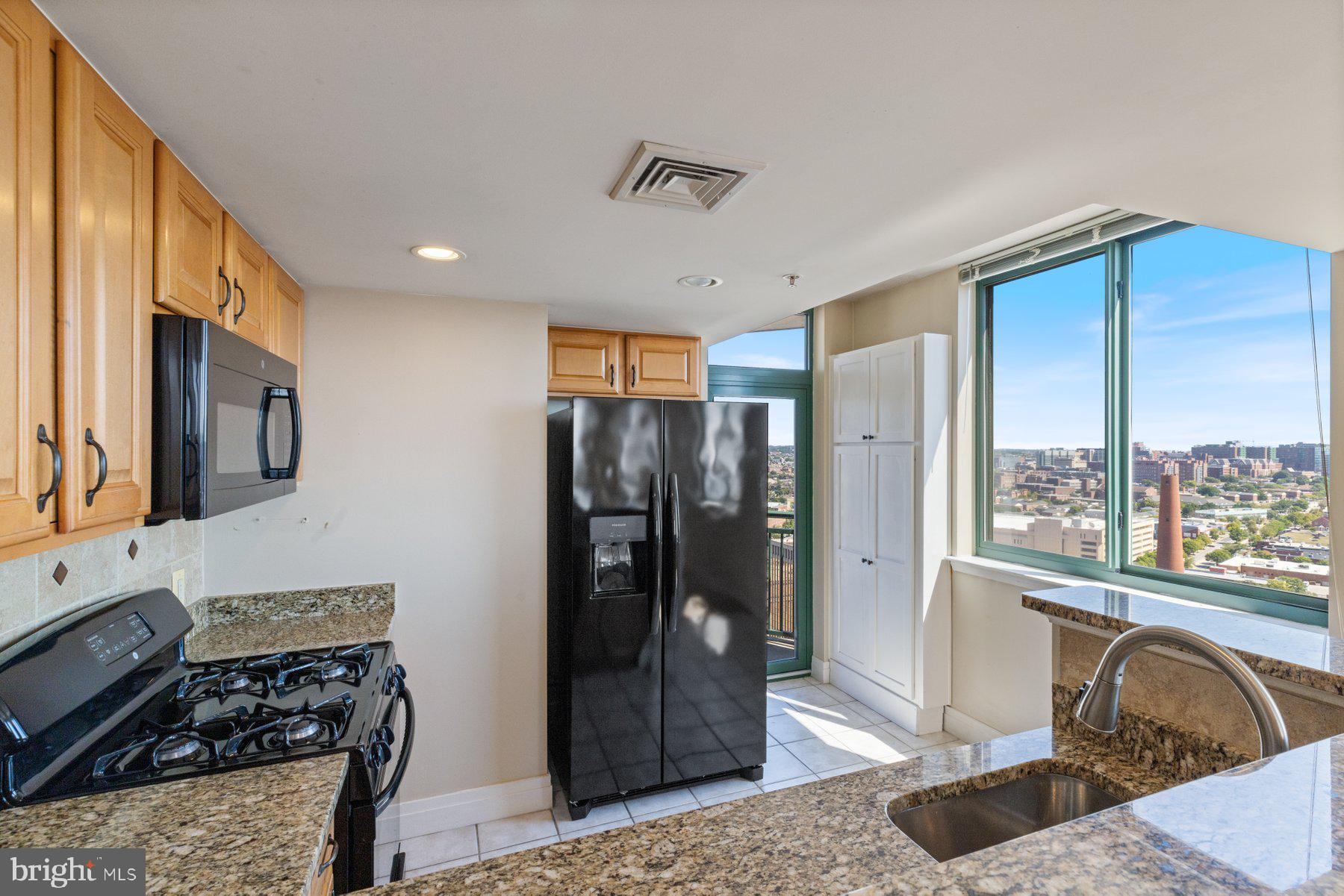 414 Water Street, Unit 2512 Baltimore, MD 21202 - Photo 10 of 40 a kitchen with stainless steel appliances granite countertop a refrigerator and a stove top oven