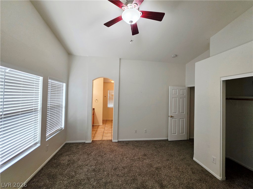 1571 Rusty Ridge Lane Henderson, NV 89002 - Photo 15 of 26 A spacious bedroom features vaulted ceilings and ample natural light from multiple windows.