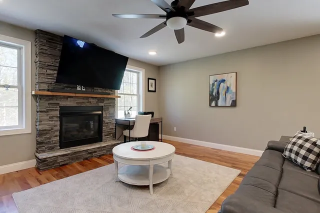 a living room with furniture a flat screen tv and a fireplace