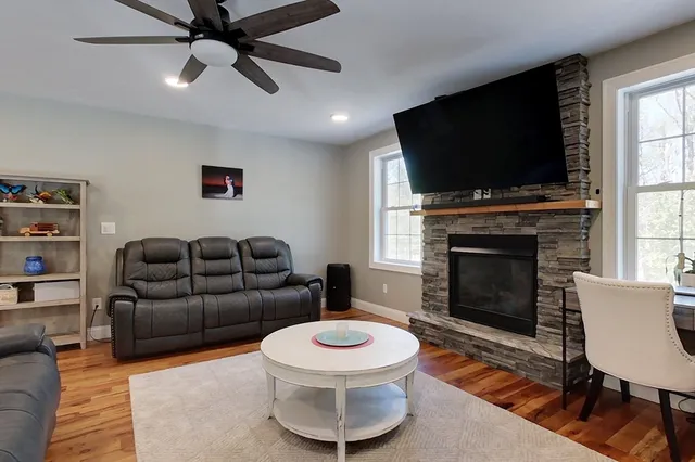 a living room with furniture a flat screen tv and a fireplace