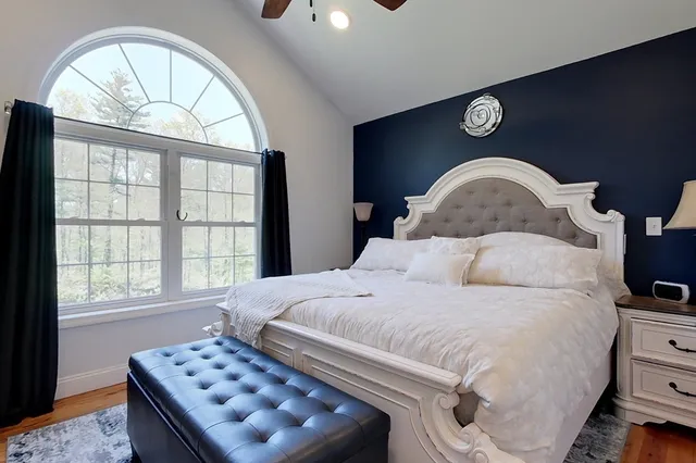 a bedroom with a bed and a large window