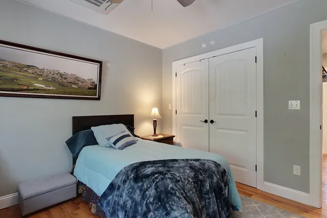 a bedroom with a bed and a painting on the wall