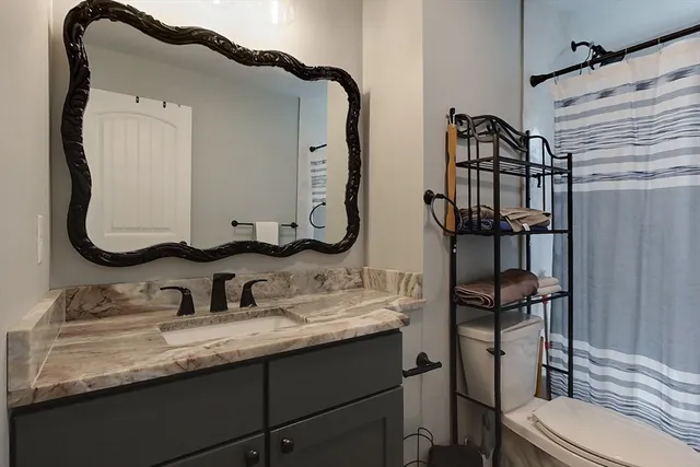 a bathroom with a granite countertop sink and a mirror