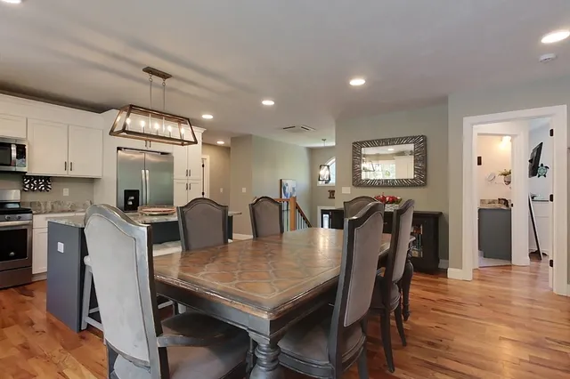 a view of a a dining room with furniture window and wooden floor