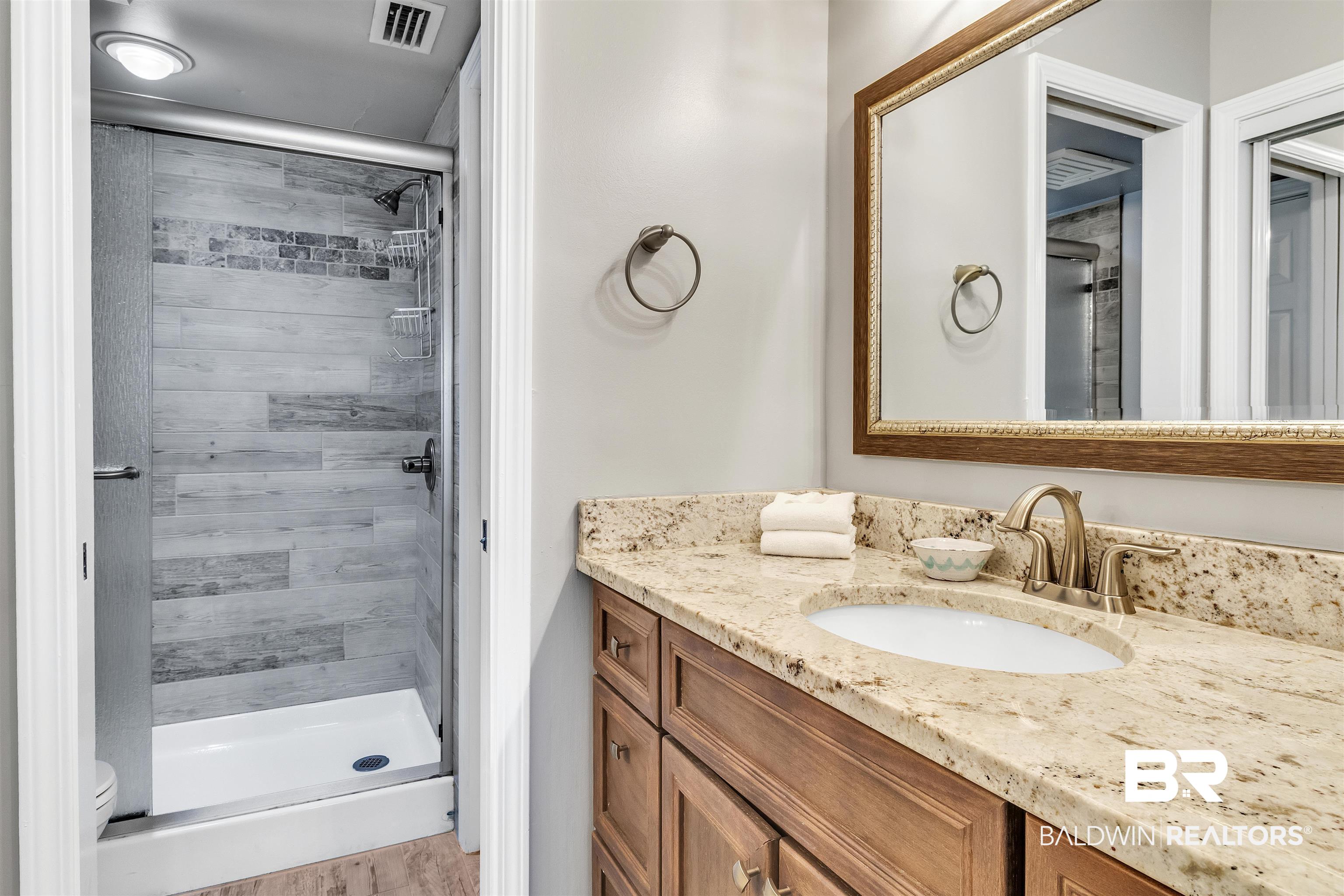645 Plantation Road, Unit 6404 Gulf Shores, AL 36542 - Photo 10 of 21 PRIMARY BATH WITH UPDATED TILED SHOWER & UPDATED VANITY WITH GRANITE COUNTERTOP