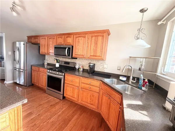 a kitchen with stainless steel appliances granite countertop a stove sink and refrigerator
