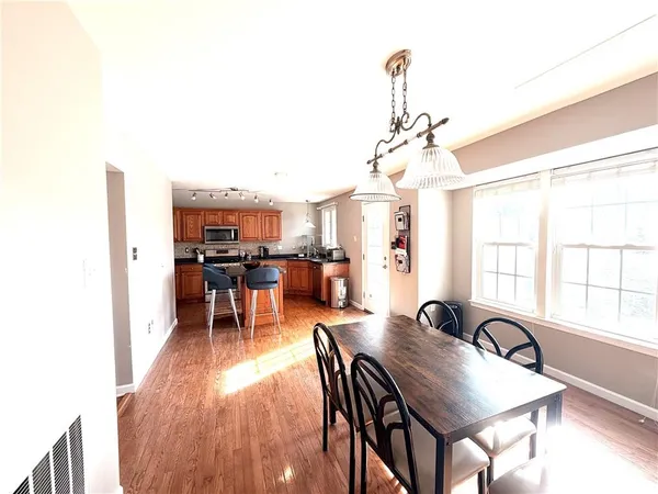 a view of a a dining room with furniture window and wooden floor