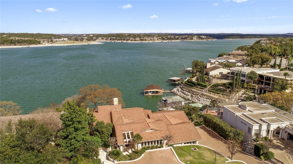 an aerial view of ocean and residential houses with outdoor space