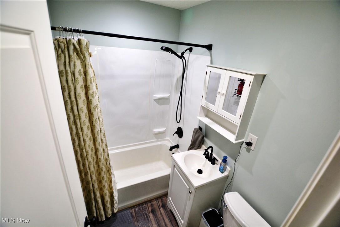 1795 Aberdeen Road Madison, OH 44057 - Photo 11 of 24 Full bathroom featuring shower / bath combination with curtain, vanity, wood finished floors, and toilet