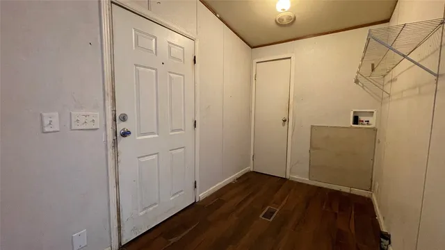 a view of a hallway with wooden floor and closet area