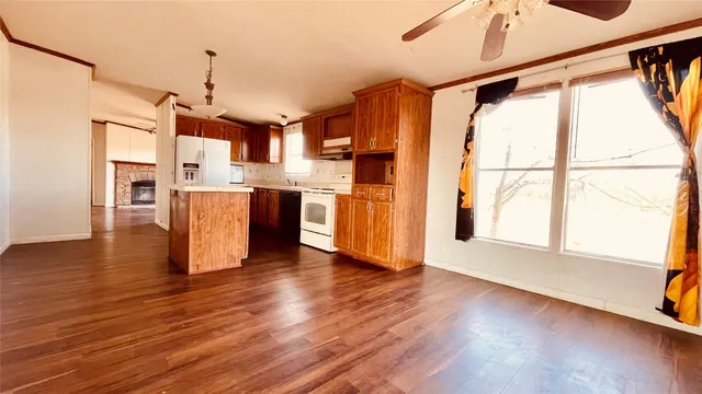 a view of a kitchen with a stove wooden cabinets and wooden floor