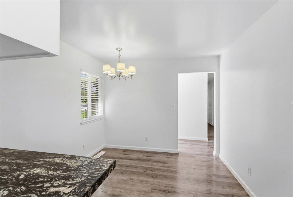 209 Tokay Avenue Modesto, CA 95350 - Photo 11 of 30 a view of an empty room with wooden floor and a window
