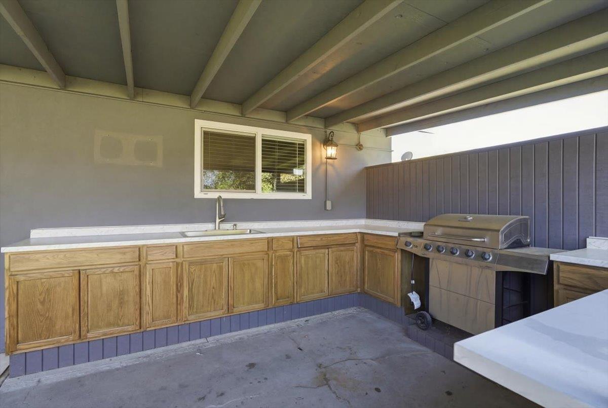 209 Tokay Avenue Modesto, CA 95350 - Photo 22 of 30 a kitchen with a sink and wooden cabinets