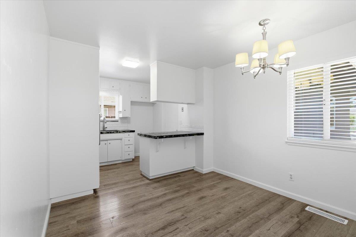 209 Tokay Avenue Modesto, CA 95350 - Photo 7 of 30 a kitchen with a white cabinets and wooden floor