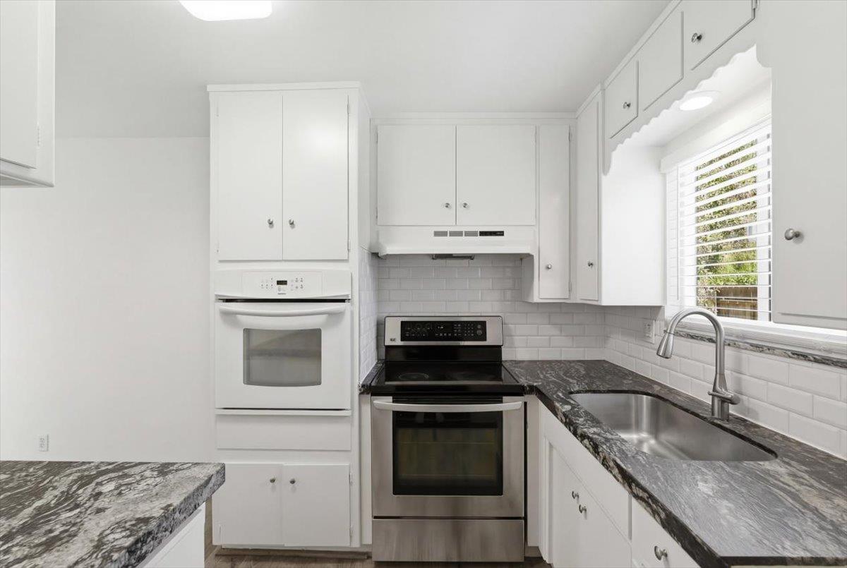 209 Tokay Avenue Modesto, CA 95350 - Photo 9 of 30 a kitchen with granite countertop white cabinets and stainless steel appliances