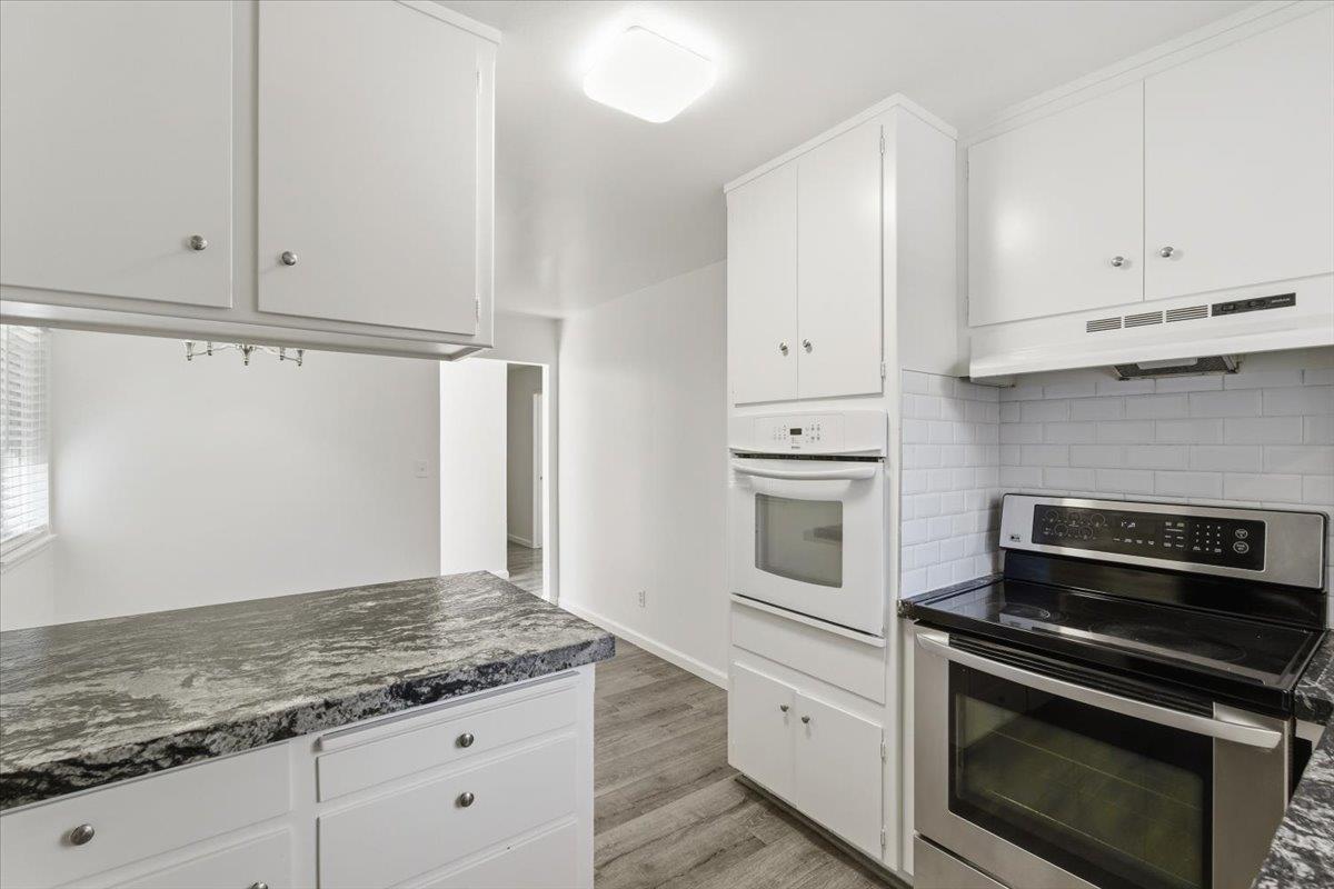 209 Tokay Avenue Modesto, CA 95350 - Photo 10 of 30 a kitchen with granite countertop white cabinets and stainless steel appliances