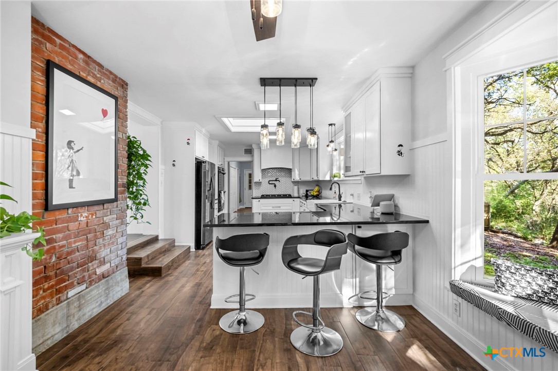 2509 Forest Trail Temple, TX 76502 - Photo 13 of 42 a kitchen with stainless steel appliances granite countertop a stove a refrigerator a sink a dining table and chairs with wooden floor