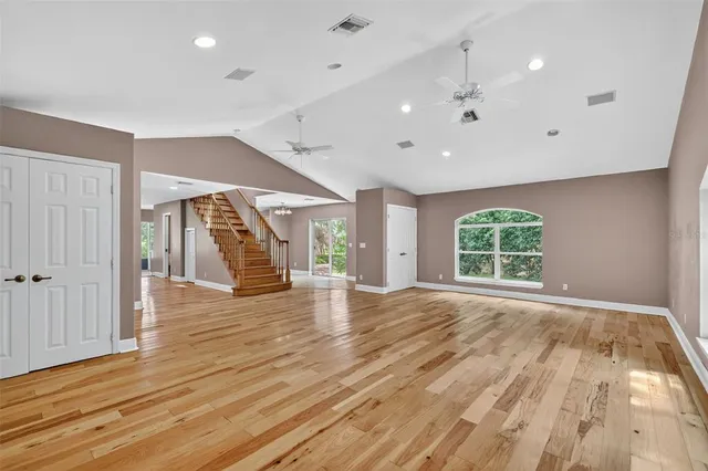 a view of an empty room with a chandelier fan