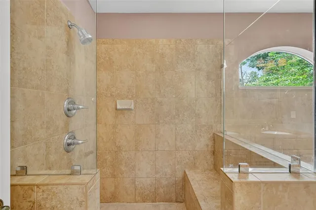an empty room with chandelier fan and windows