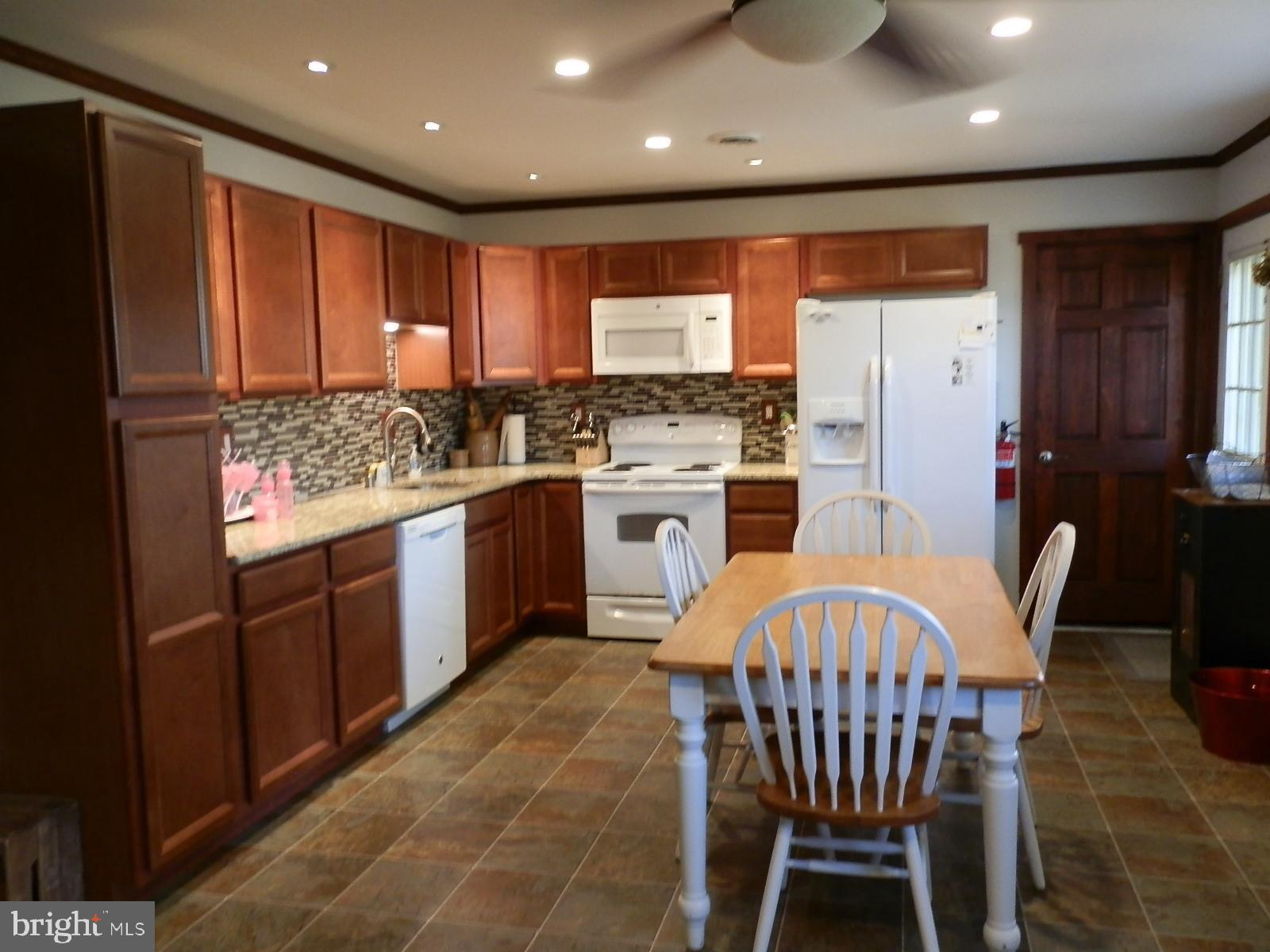 10 Georgia Road Pennsville, NJ 08070 - Photo 4 of 48 a kitchen with stainless steel appliances granite countertop a stove a sink dishwasher and a refrigerator with wooden cabinets