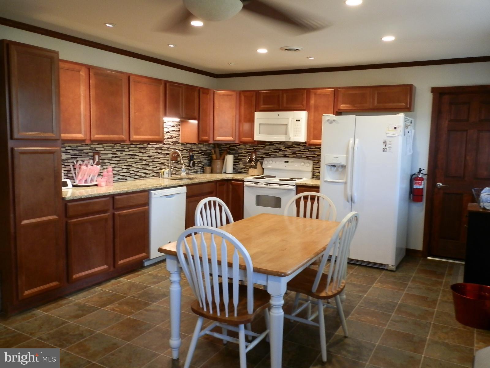 10 Georgia Road Pennsville, NJ 08070 - Photo 5 of 48 a kitchen with stainless steel appliances granite countertop a stove a refrigerator a kitchen island and chairs