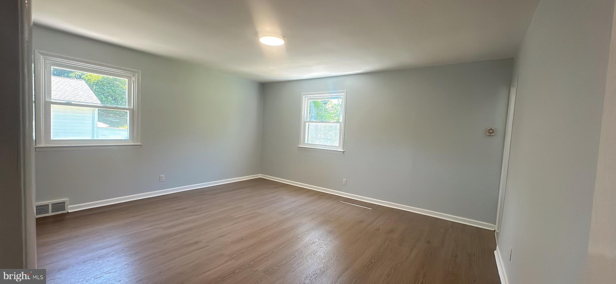 1242 June Road Huntingdon Valley, PA 19006 - Photo 35 of 47 an empty room with wooden floor and windows