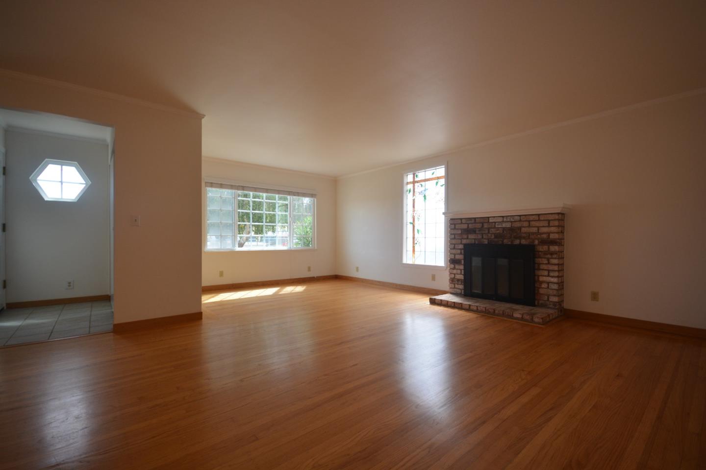 224 Park Boulevard Millbrae, CA 94030 - Photo 3 of 17 an empty room with wooden floor fireplace and windows