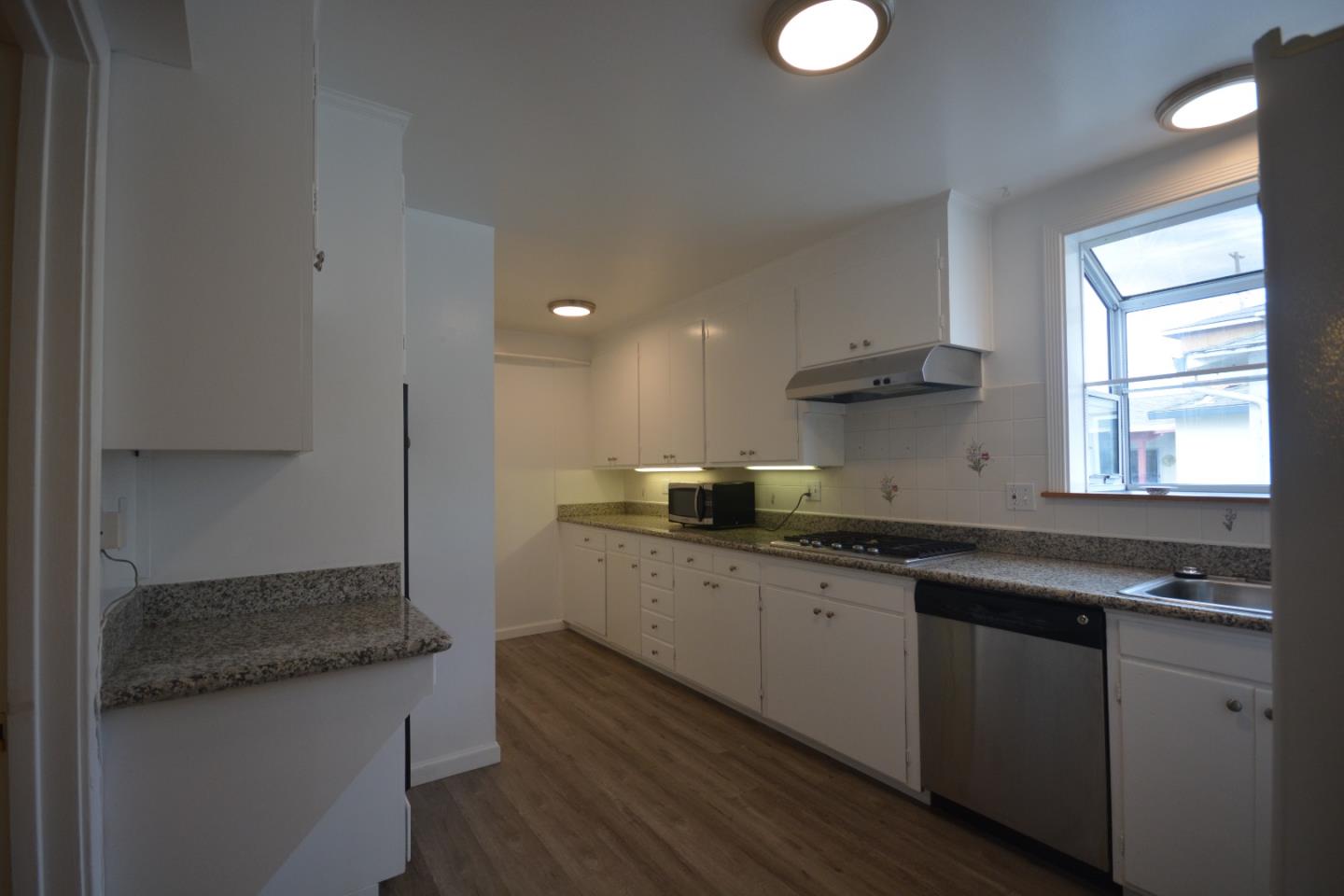 224 Park Boulevard Millbrae, CA 94030 - Photo 6 of 17 a kitchen with stainless steel appliances granite countertop a sink a stove and a wooden floors