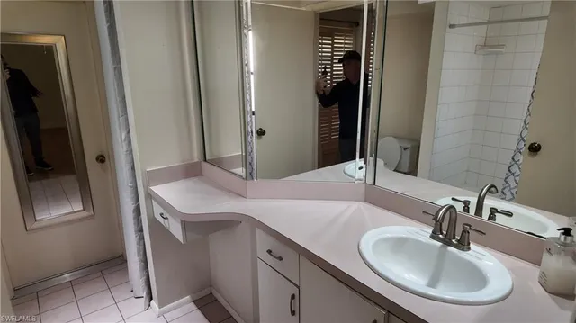 a bathroom with a double vanity sink mirror and shower