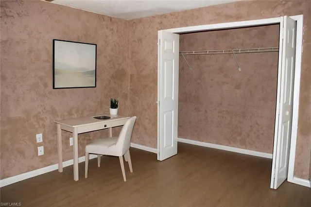 a view of a big room with wooden floor and windows