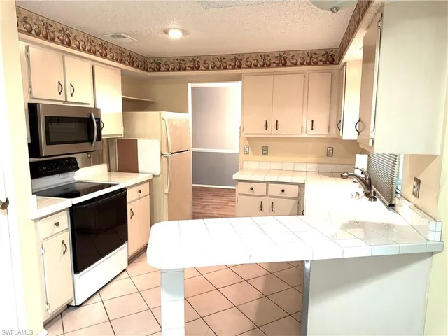 a kitchen with stainless steel appliances kitchen island granite countertop a sink stove and refrigerator