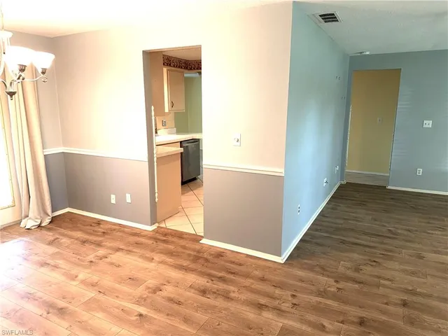 a view of a room with wooden floor and a bathroom