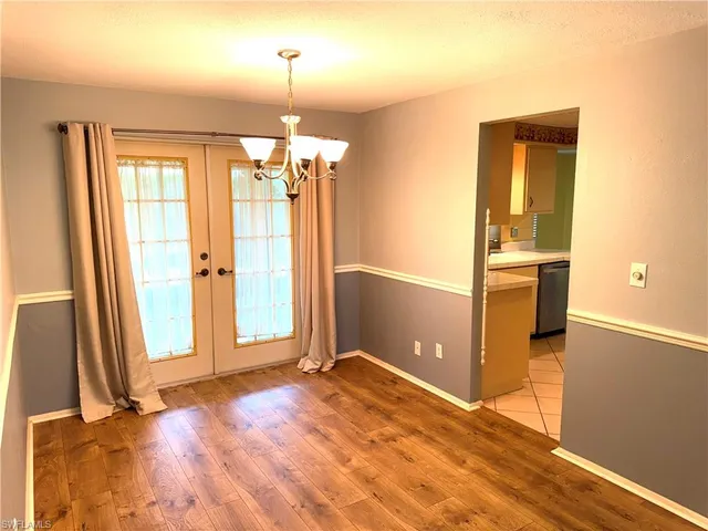 an empty room with wooden floor and a window