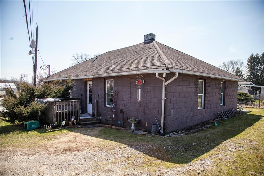 107 Madison Road Grindstone, PA 15442 - Photo 14 of 14 a backyard of a house with a barn table and chairs with plants