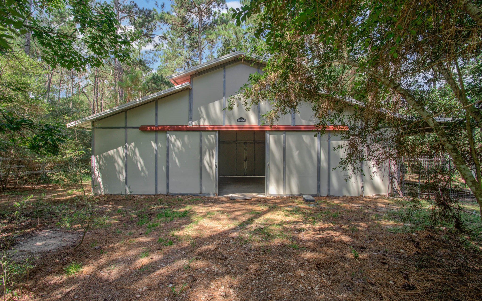 20203 Timber Ridge Drive Magnolia, TX 77355 - Photo 37 of 49 A standout feature of the property is the impressive multi-purpose barn/workshop hidden in the back of the property. Designed with generous proportions, vaulted ceilings, and oversized access doors.