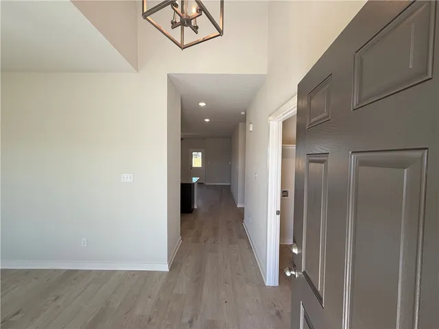 a view of an empty room with a window and a kitchen