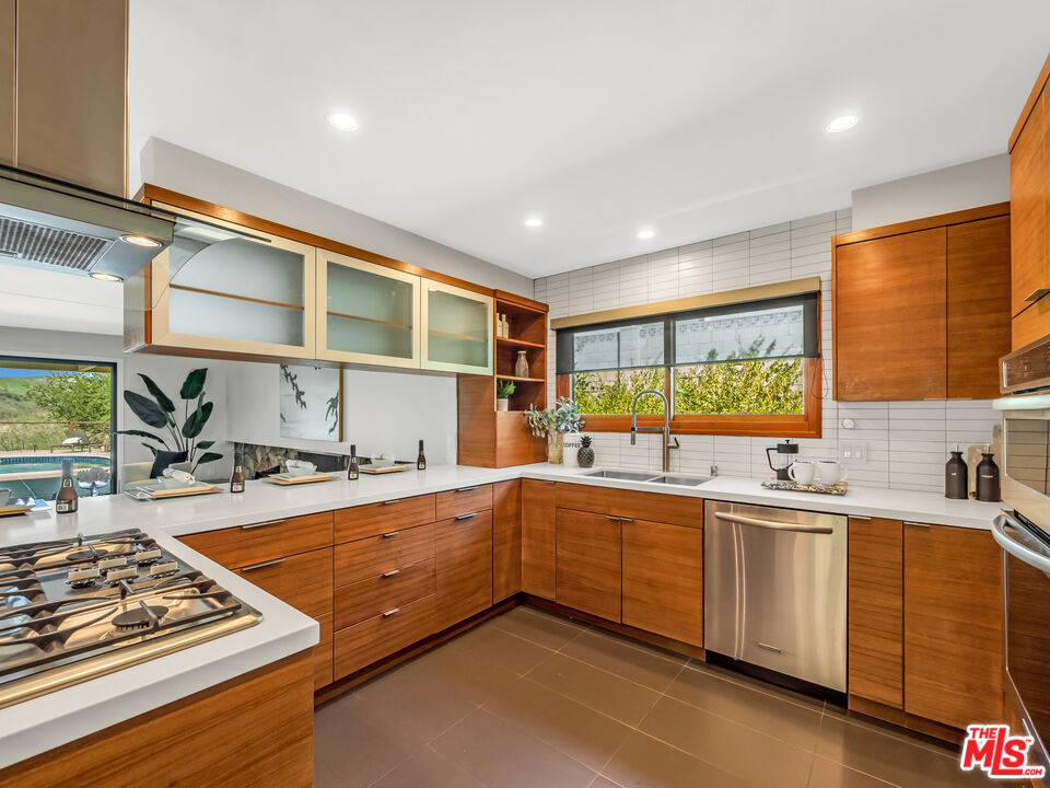 26077 Farmfield Road Calabasas, CA 91302 - Photo 8 of 45 a kitchen with stainless steel appliances a sink and cabinets