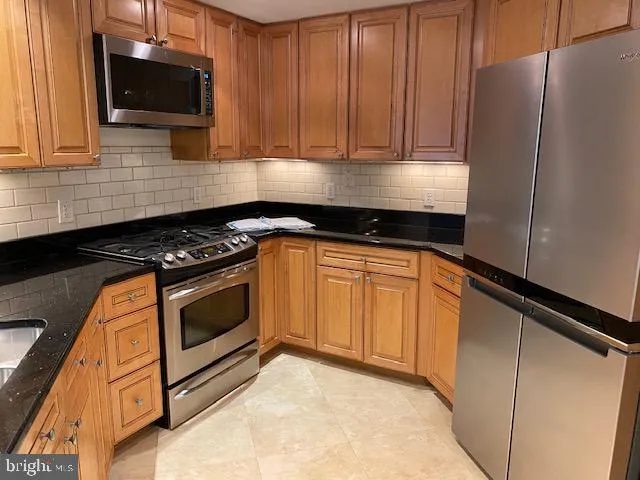 a kitchen with granite countertop cabinets stainless steel appliances and a sink