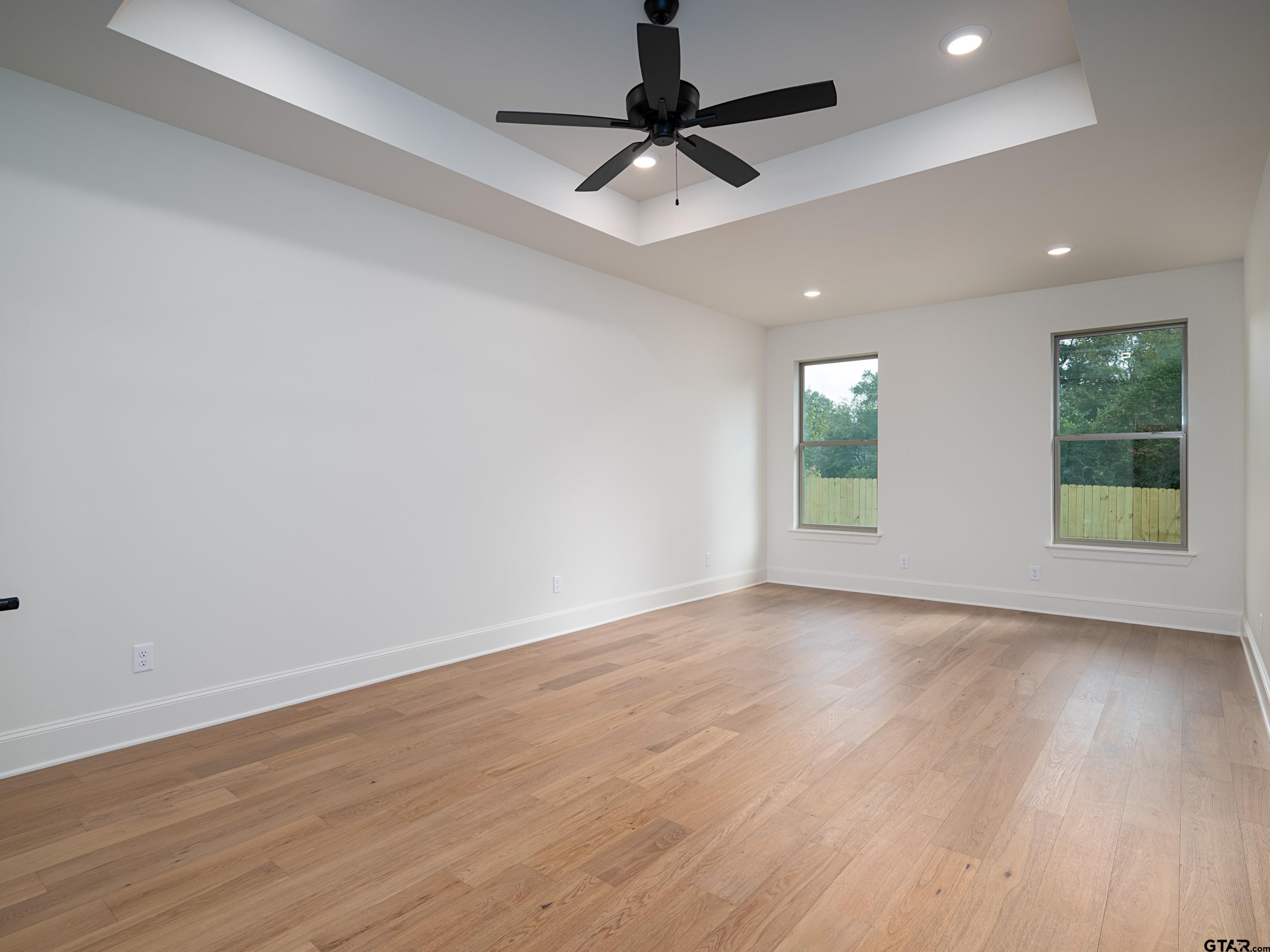 5216 Hollytree Drive Tyler, TX 75703 - Photo 14 of 28 a view of an empty room with window and wooden floor