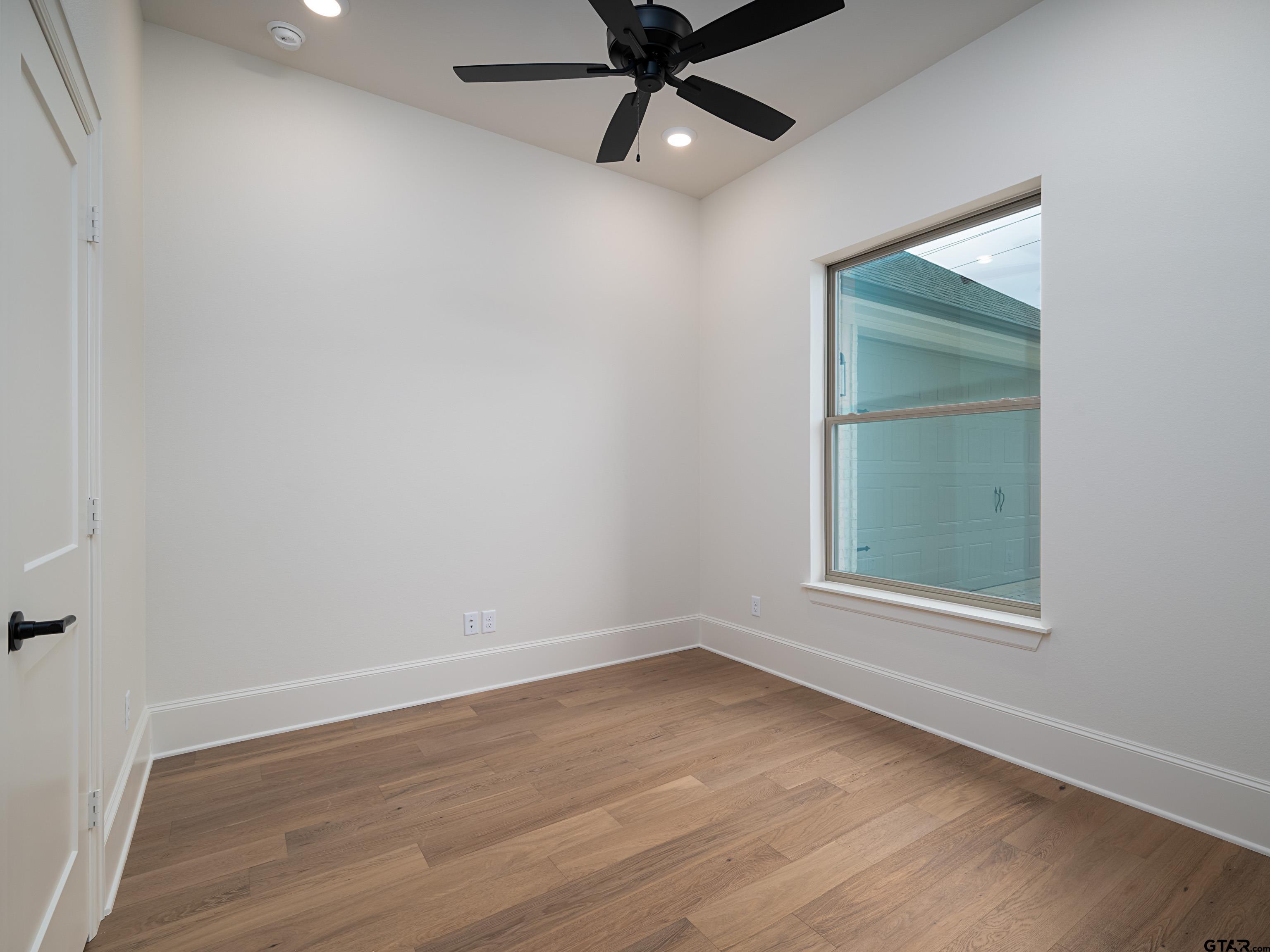 5216 Hollytree Drive Tyler, TX 75703 - Photo 26 of 28 an empty room with a window and a ceiling fan