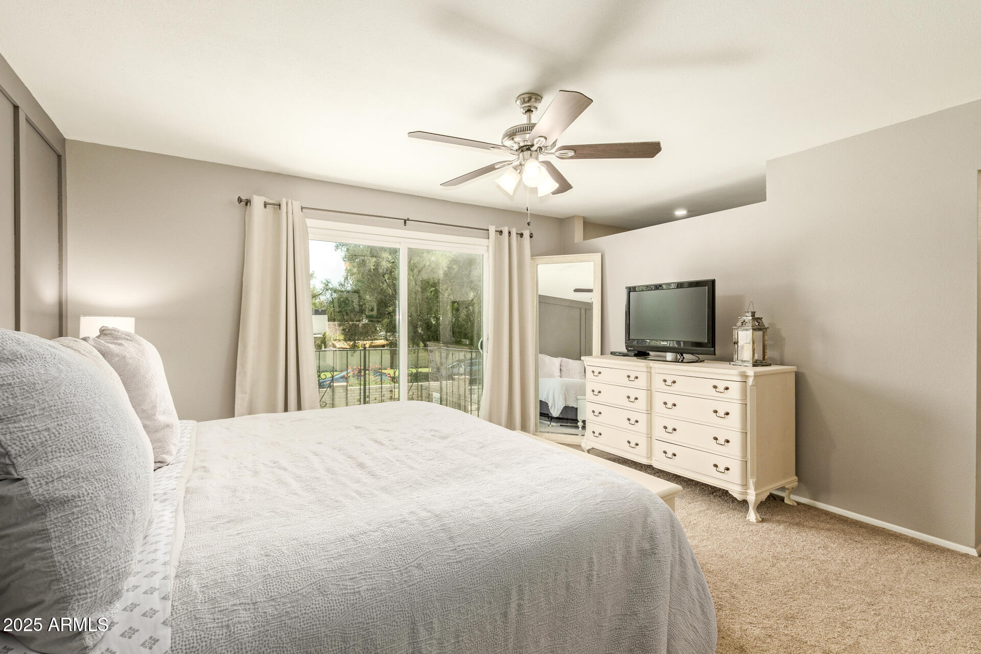 8135 North Central Avenue, Unit 7 Phoenix, AZ 85020 - Photo 10 of 25 a bedroom with a large bed and flat tv screen on the dresser